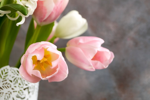 Tulipes blanches et roses dans un vase blanc.