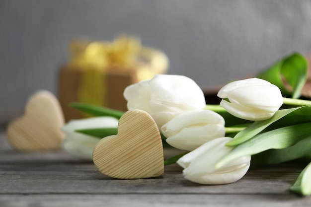 Tulipes blanches sur une table en bois se bouchent