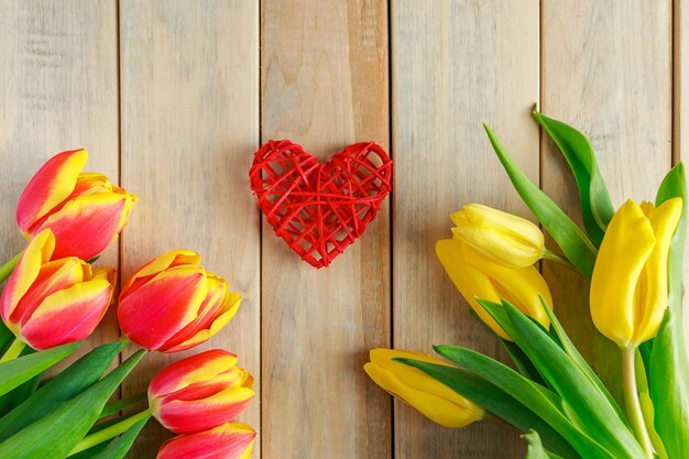 Des tulipes et un cœur sur fond en bois concept de carte de vœux pour la Saint-Valentin