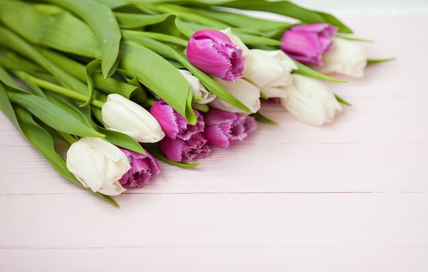 Photo tulipes fraîches sur un fond en bois blanc pour la fête des mères