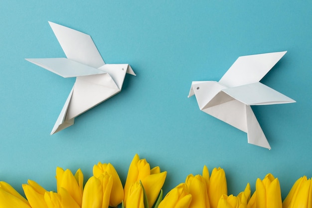 Tulipes jaunes et deux oiseaux blancs comme symbole de paix sur fond bleu Il n'y a pas de guerre Arrêtez la guerre