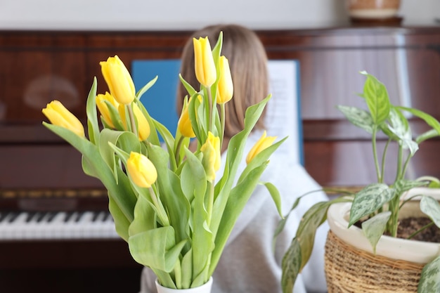 Tulipes jaunes et plante d'intérieur sur la table