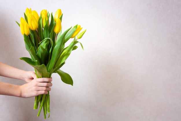 Tulipes jaunes de printemps Femme tenant un bouquet sur fond blanc Mise à plat Vue de dessus Tulip flower