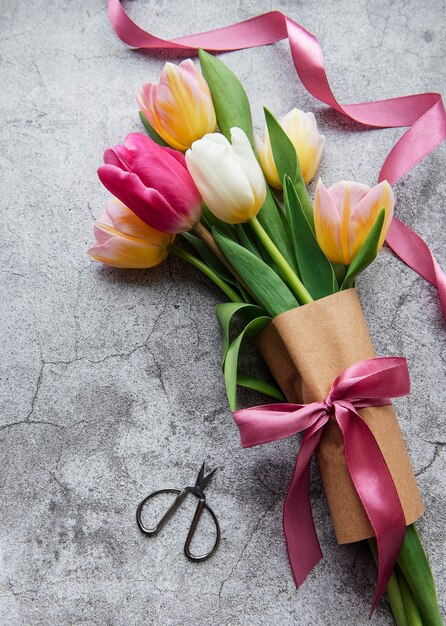 Tulipes de printemps colorées sur une surface en béton