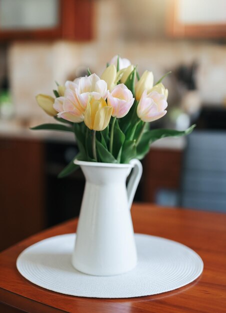 Photo des tulipes de printemps dans un vase sur la table décor de maison de vacances de printemps