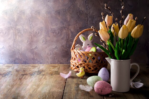 Tulipes de printemps avec des oeufs de Pâques sur fond rustique