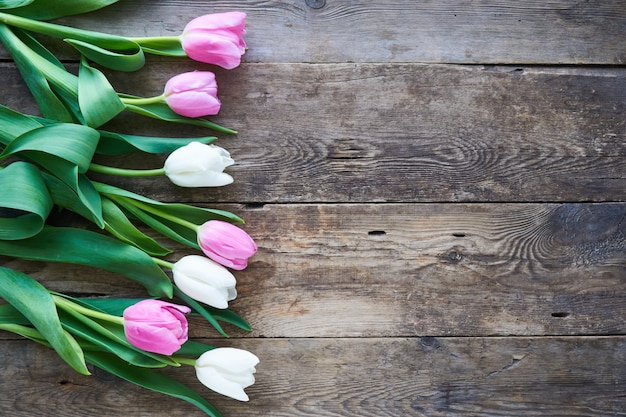 Tulipes roses et blanches sur une table en bois