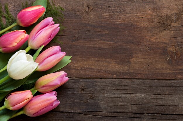 Tulipes roses et blanches sur la vue de dessus de table en bois marron avec espace copie