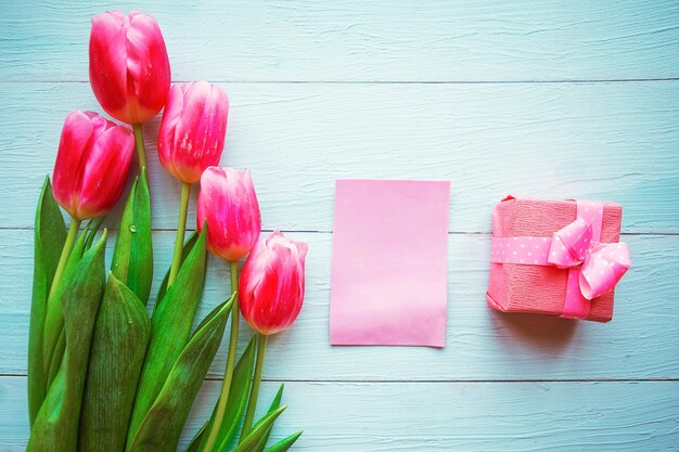Tulipes roses et boîte-cadeau sur fond en bois Carte de vœux pour Pâques ou la fête des mères
