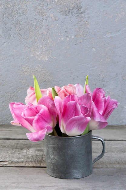 Tulipes roses dans une tasse en métal vintage