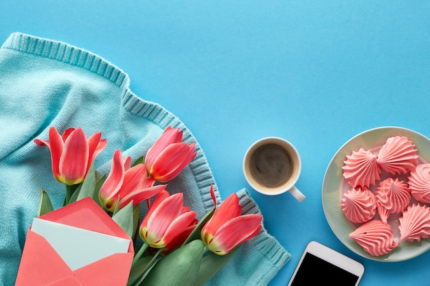 Tulipes roses sur pull en coton de couleur menthe, cartes de voeux et enveloppes, téléphone portable, assiette de guimauve et tasse de café