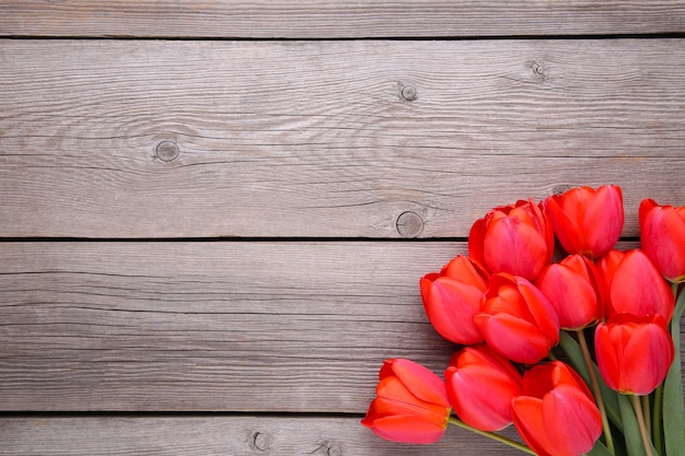 Tulipes rouges sur un bois gris.