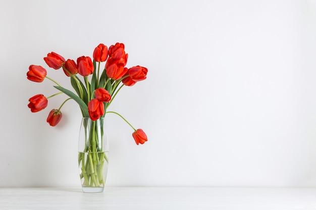 Tulipes rouges dans un vase sur la table blanc