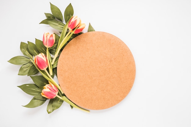 Tulipes rouges avec du papier vierge sur la table