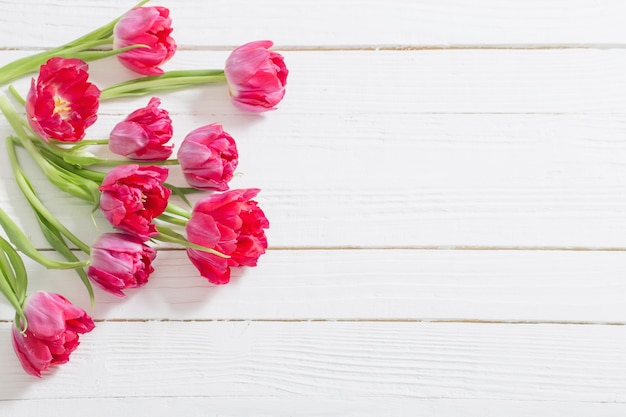 Tulipes rouges sur fond en bois blanc