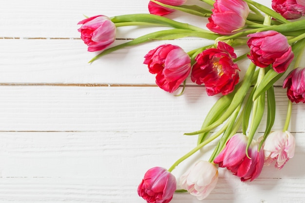 Tulipes rouges sur table en bois blanc