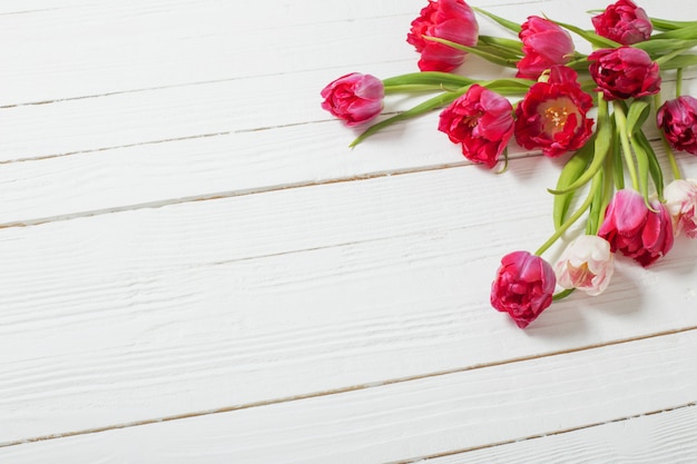 Tulipes rouges sur table en bois blanc