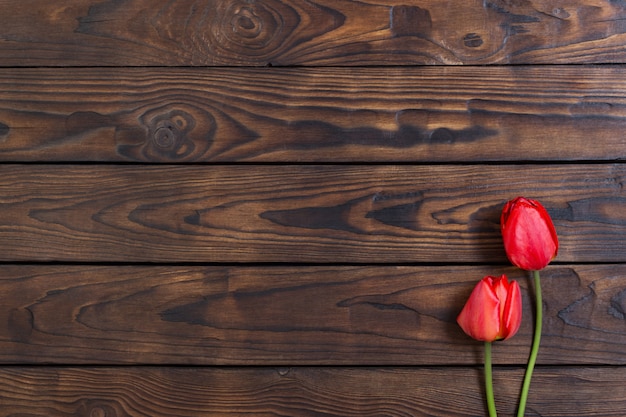 Tulipes rouges sur table en bois foncé