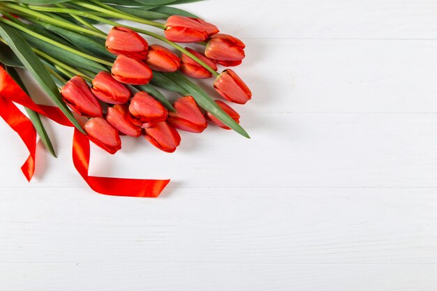 Tulipes rouges sur tableau blanc, cadre, texte vierge. Copiez l'espace.