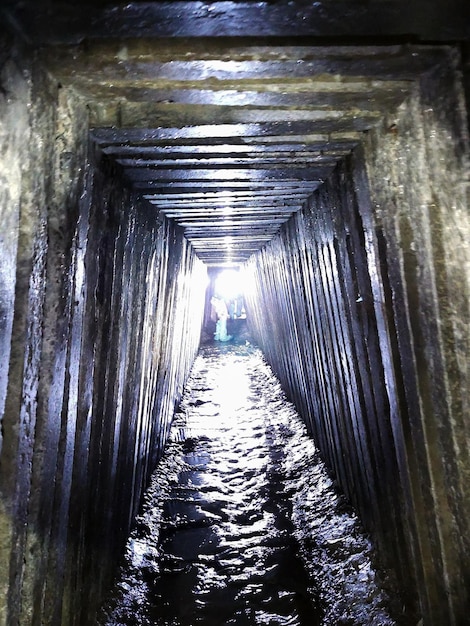 Le tunnel du collecteur d'eaux usées souterrain avec des parois nervurées allant en perspective