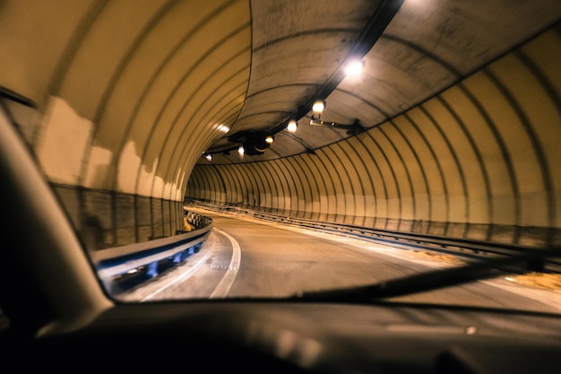 Photo tunnel éclairé vu à travers le pare-brise d'une voiture