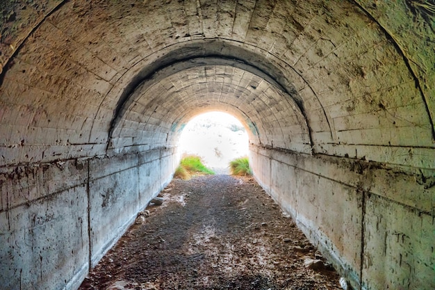 Tunnel vide abandonné sombre avec une lumière vive à la fin de celui-ci