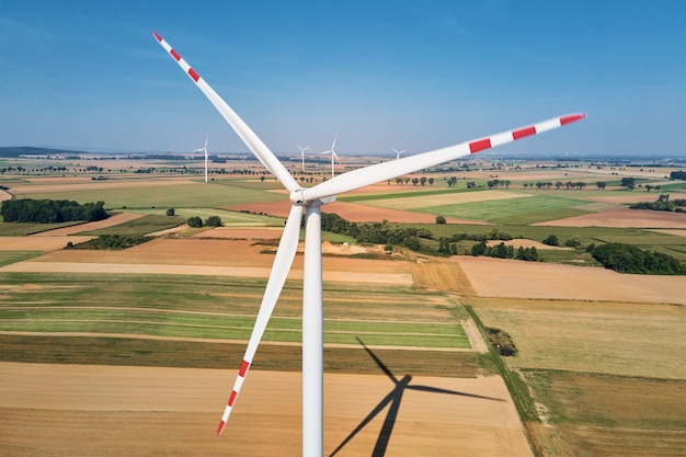 Photo turbine de moulin à vent dans le domaine au générateur de vent tournant de jour d'été