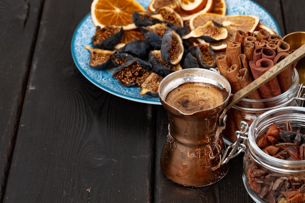 Turc de cuivre avec du café et des morceaux de fruits secs sur la table