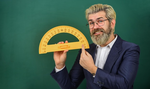 Tuteur barbu au tableau Enseignement des angles Mathématiques pour un avenir meilleur Leçon personnelle Concept de mathématiques et de personnes Matière préférée de mathématiques Un enseignant utilise l'outil de règles mathématiques