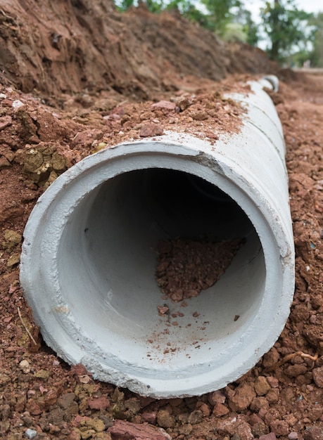 Photo tuyau de drainage en béton sur un site de construction. tuyau en béton, système d’eaux usées superposées.