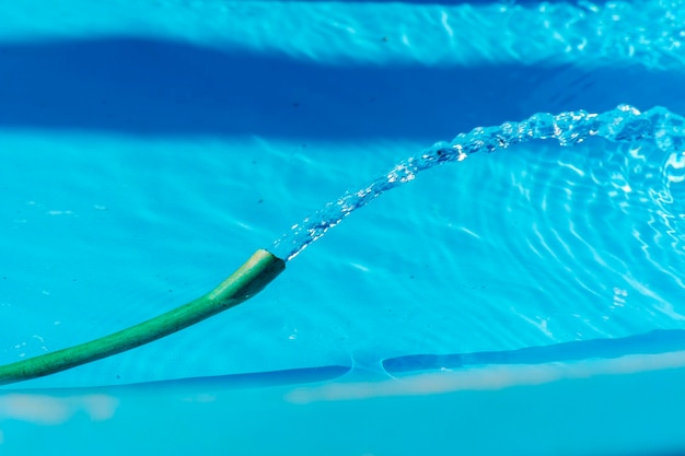 Tuyau avec de l'eau dans la piscine