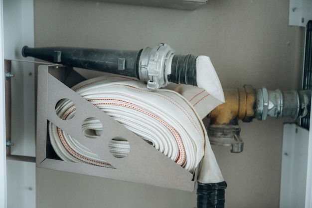 Le tuyau d'incendie est contre le mur, prêt à être utilisé.