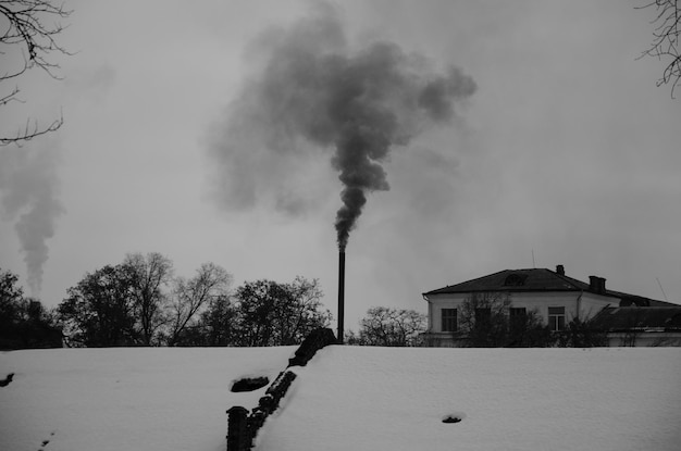 Tuyau industriel et fumée contre le ciel