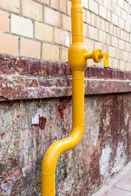 Tuyau jaune sur le mur d'un immeuble urbain