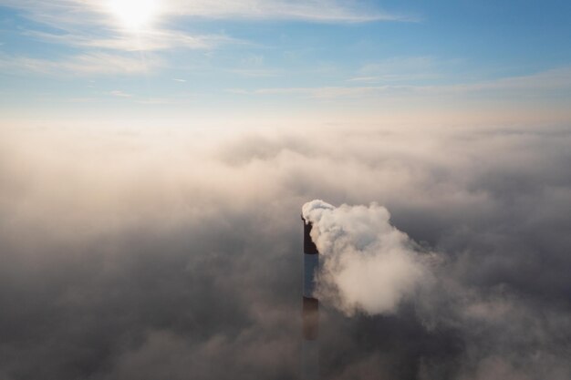 Tuyau de l'usine au-dessus des nuages Émissions nocives dans la haute atmosphère