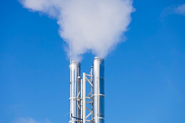 Tuyaux D'argent D'où Il Y A De La Fumée Dans Le Ciel Bleu. Photo De Haute Qualité