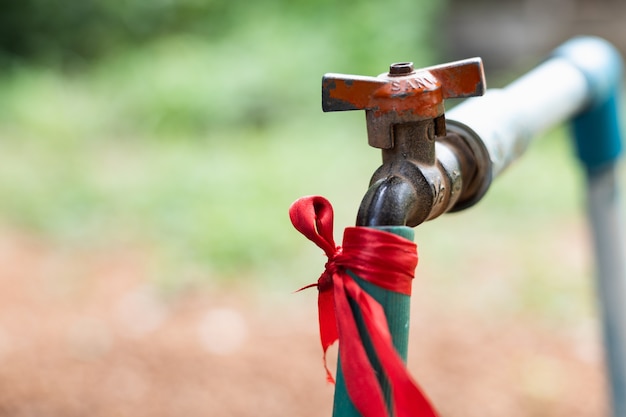 Des tuyaux qui se connectent au robinet avec un vieux connecteur à l'arrière de la maison