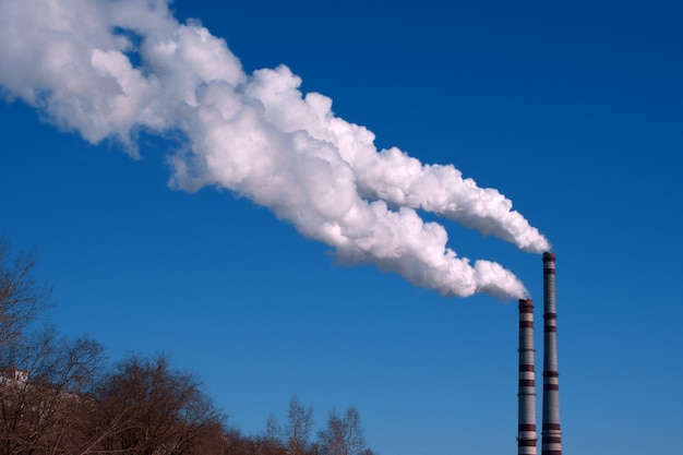 Tuyaux d'usine et nuage blanc de pollution