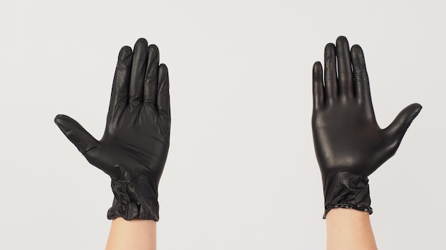 Two Hands porte des gants en latex noir sur fond blanc