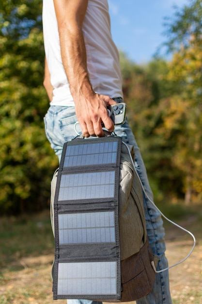 Un type charge son téléphone avec un panneau solaire.