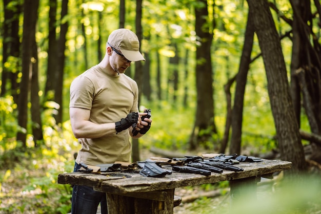 Un type dans les bois teste ses armes pour le tir sportif.