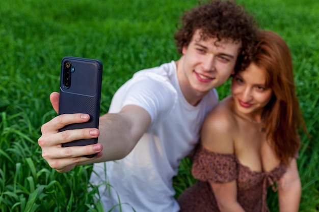 Un type avec une fille prend un selfie sur le téléphone