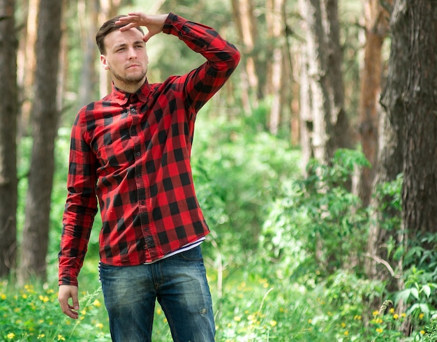 Le type à la mode se repose dans une forêt de pin