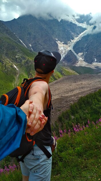 Le type tient la main de la fille dans les montagnes