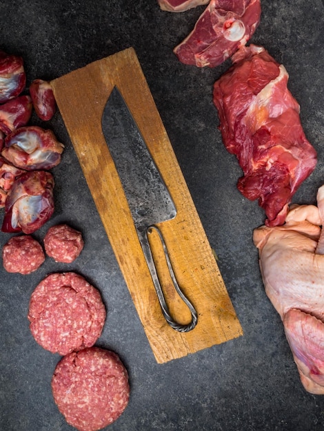 Types mixtes de viande fraîche crue sur planche à découper avec couteau