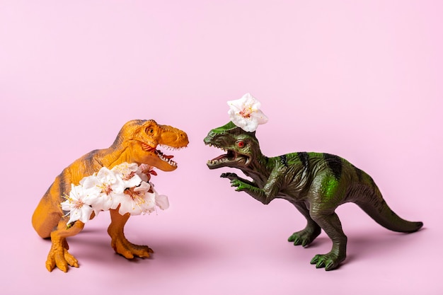 Tyrannosaurus dinosaure jouet tenant une fleur d'abricot dans ses pattes