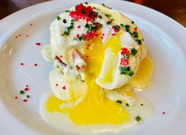 Œuf Bénédicte au saumon fumé, gilet joliment coulant sur une assiette blanche.