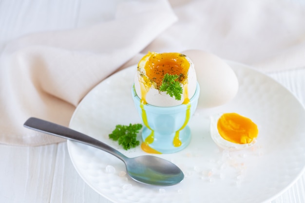 Œuf à la coque dans un coquetier aux herbes et épices pour le petit déjeuner