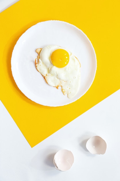 Œuf frit sur une assiette blanche