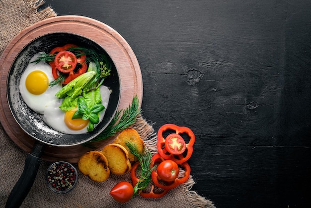 Œuf frit aux herbes pain grillé et légumes dans une poêle Vue de dessus Espace libre